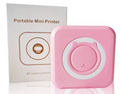Portable mini Bluetooth photo printer in pink, printing a photo wirelessly from a smartphone
